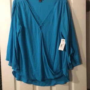 Turquoise blouse with arm slits and ties.